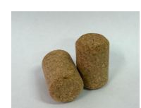Two champagne cork stoppers standing on a light background